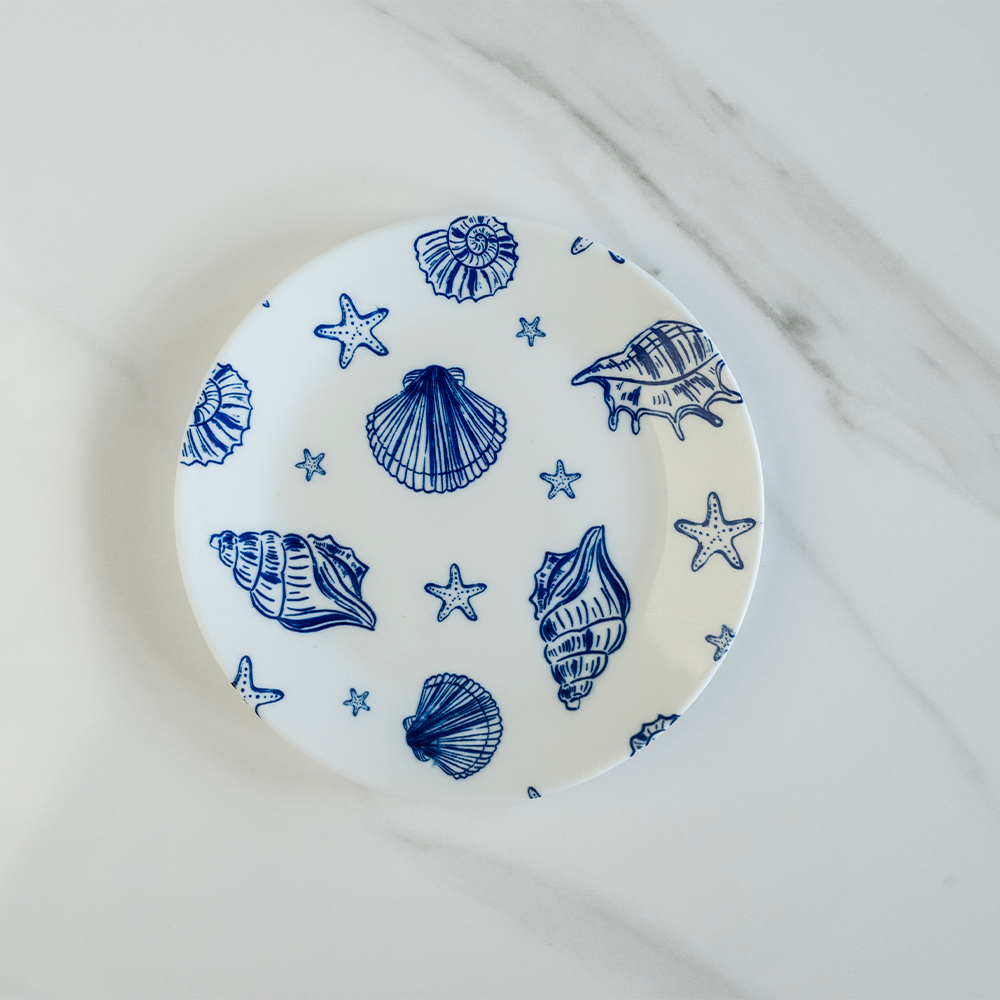 Bone china snack plate featuring a blue nautical pattern of seashells and starfish