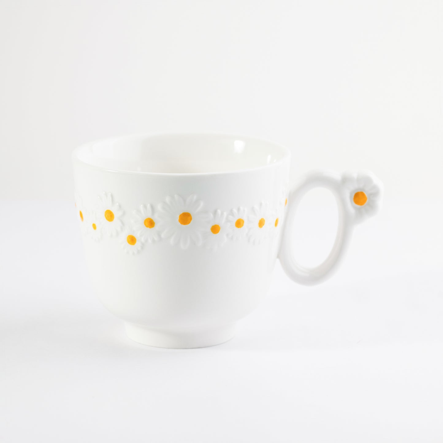 White bone china cappuccino mug with embossed white daisy patterns and a flower detail on the handle - Birdy Home Design