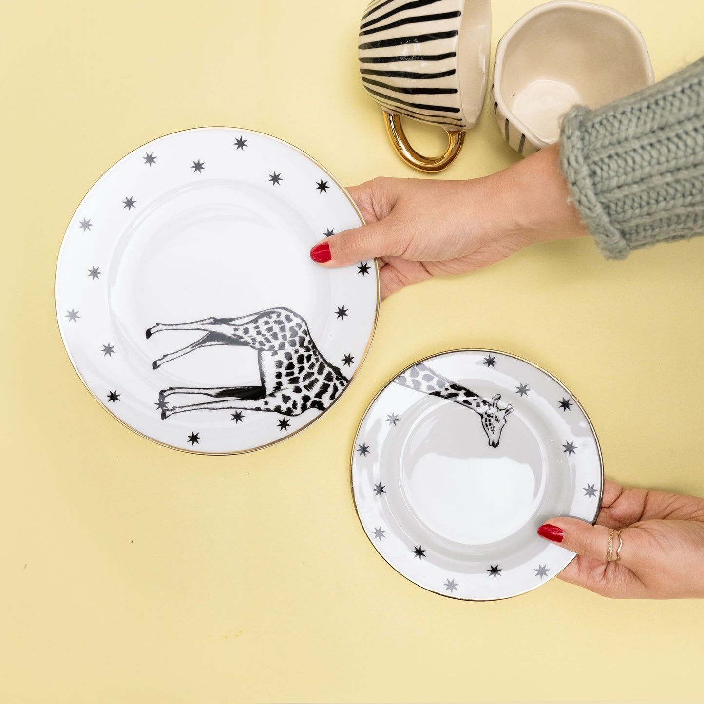 A set featuring one white bone china dinner plate and one matching 7-inch quarter plate, both with black and white giraffe illustrations and star borders - Birdy Home Design