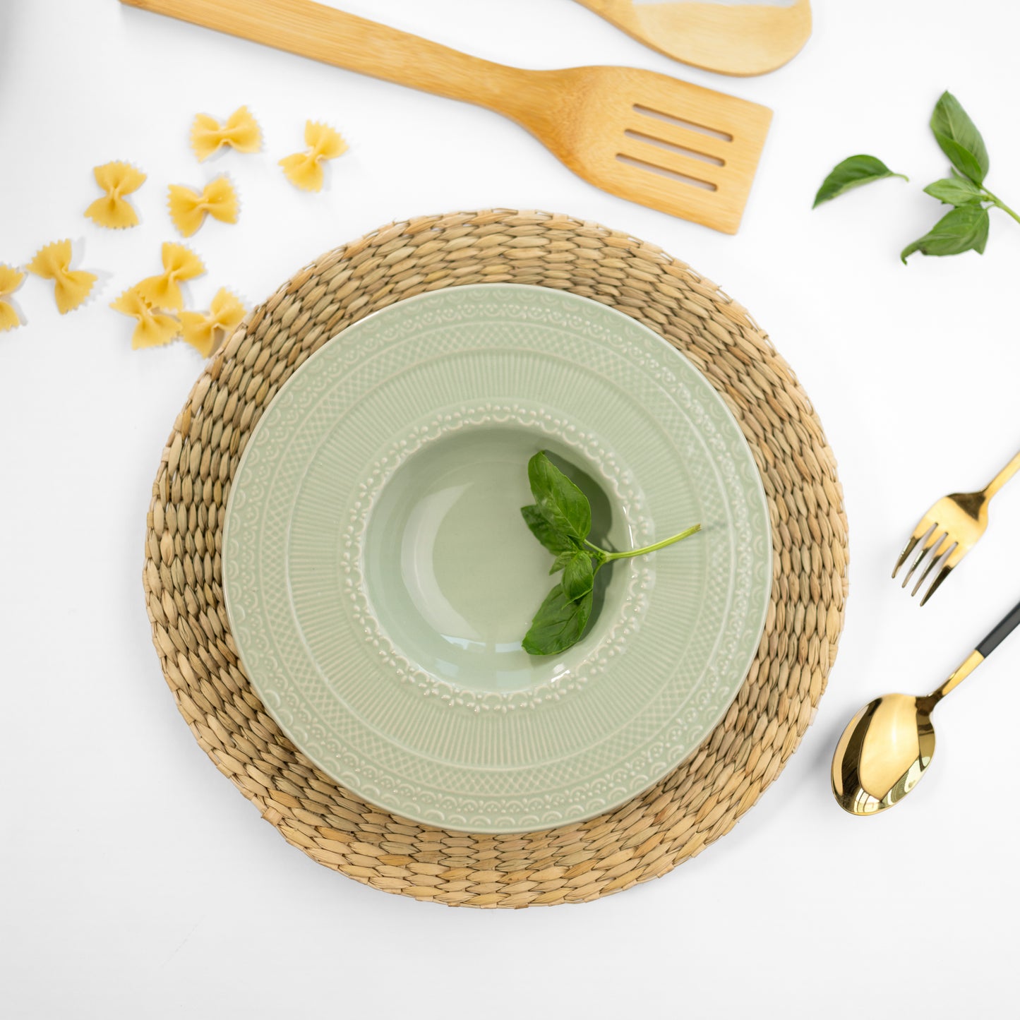 Top-down view of a jade green bone china pasta plate with engraved patterns on the rim