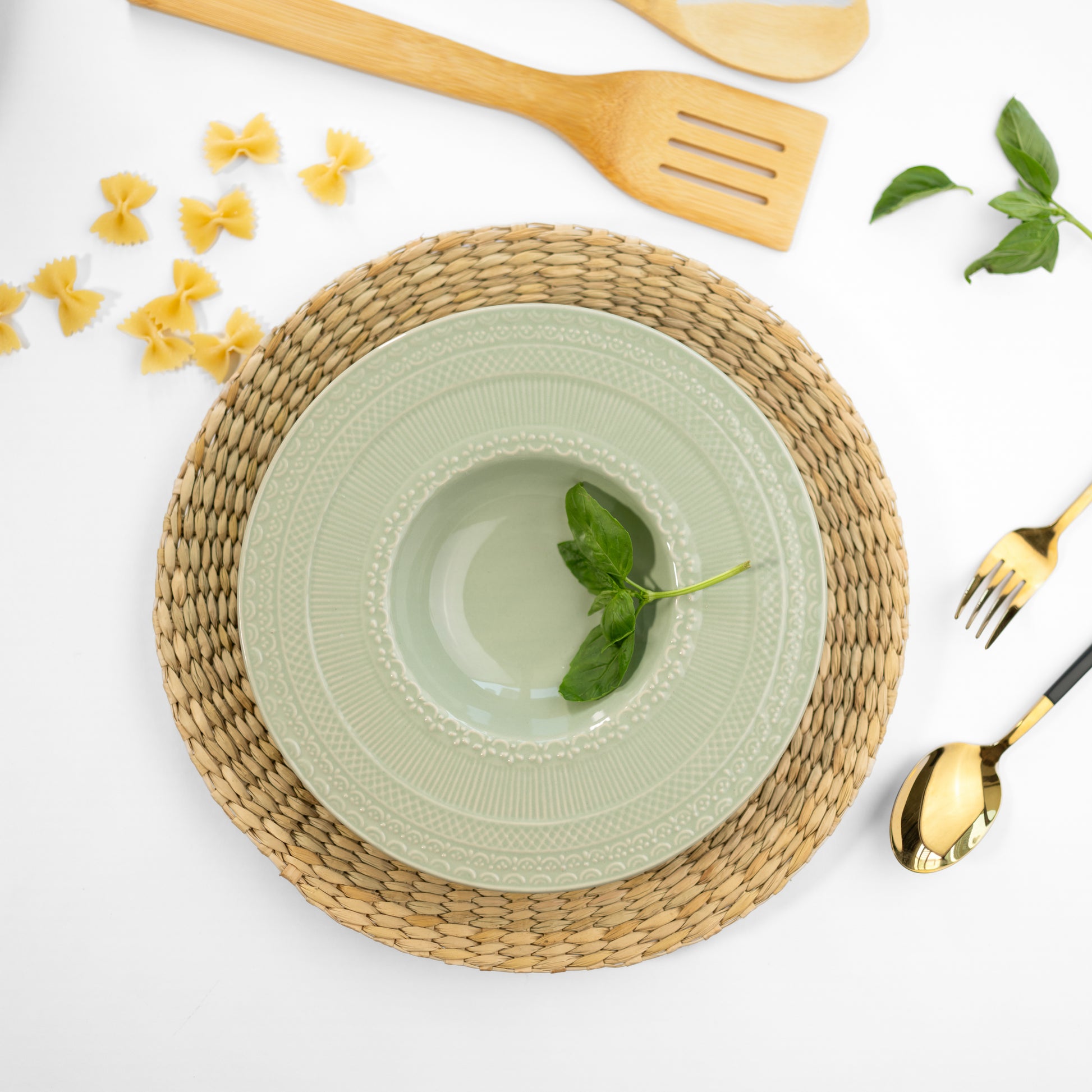 Top-down view of a jade green bone china pasta plate with engraved patterns on the rim