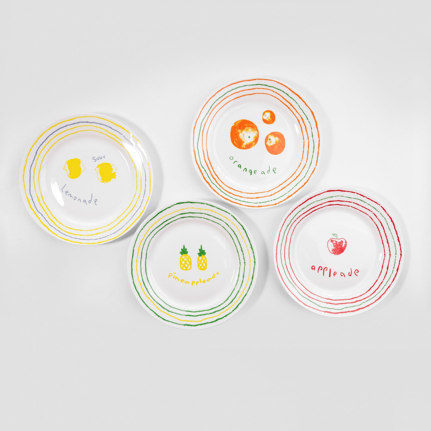 Group view of four white bone china quarter plates featuring the Lemonade, Orangeade, Appleade, and Pineappleade fruit styles