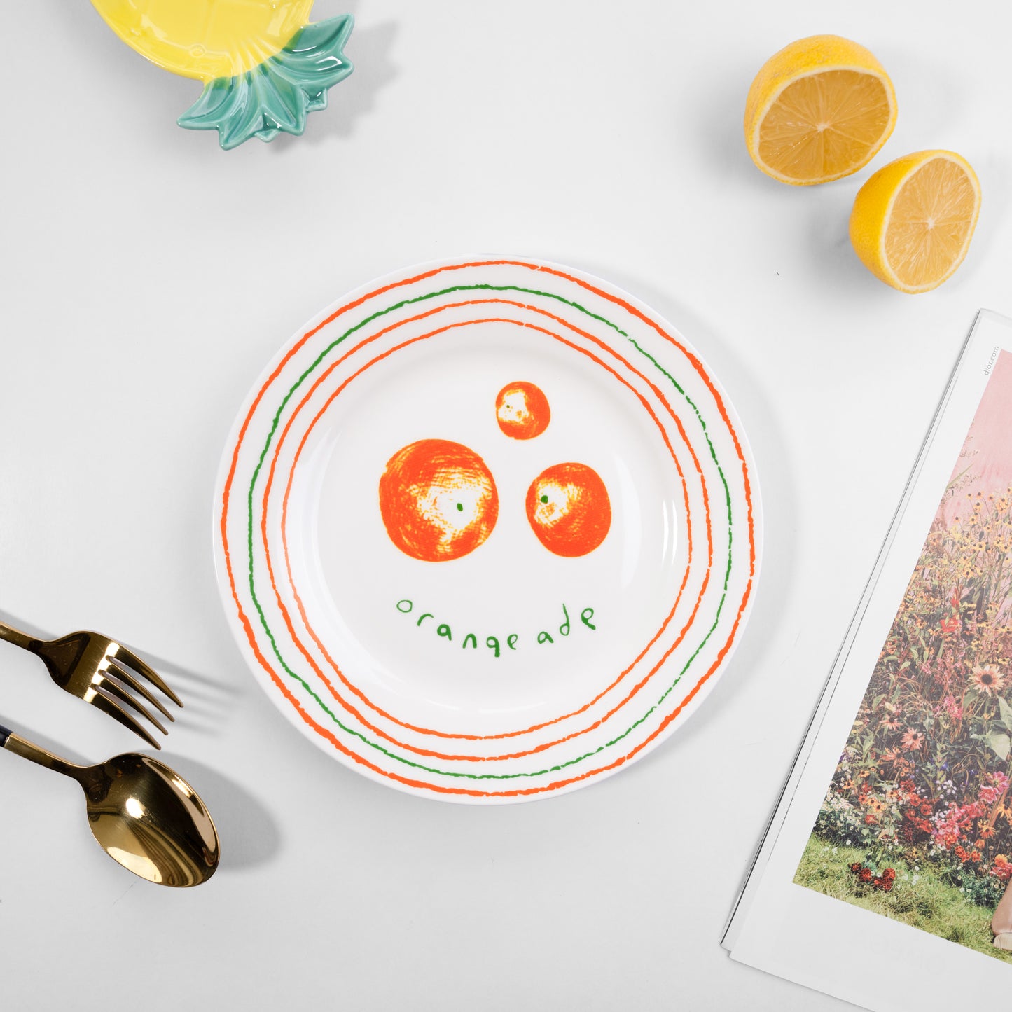 Top-down view of a white bone china quarter plate in the Orangeade style featuring orange fruits and green and orange circular borders