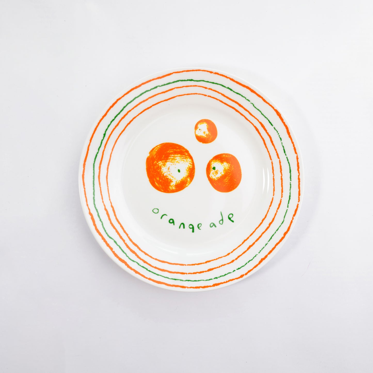Top-down view of a white bone china quarter plate in the Orangeade style featuring orange fruits and orange and green circular borders