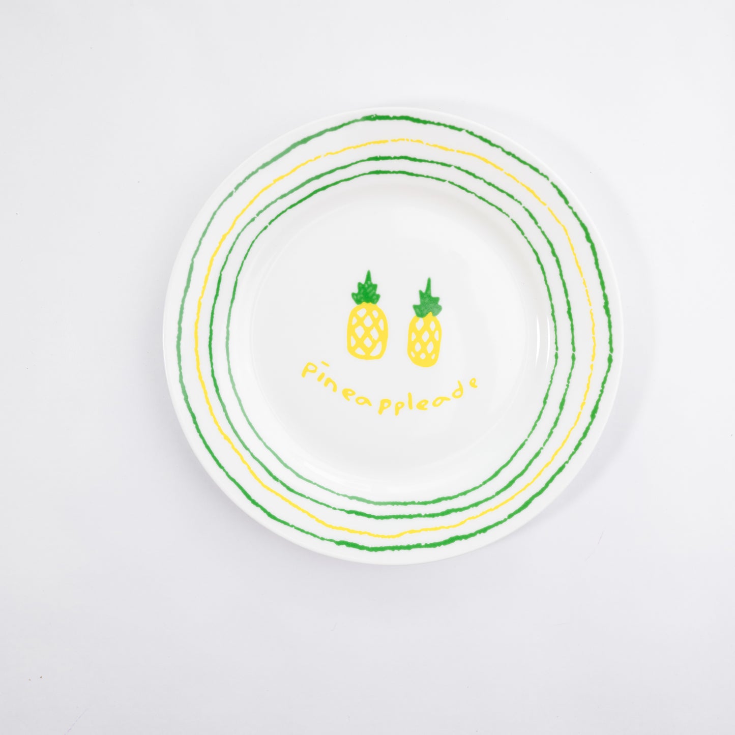 White bone china quarter plate with the Pineappleade style featuring two yellow pineapples and green and yellow circular borders