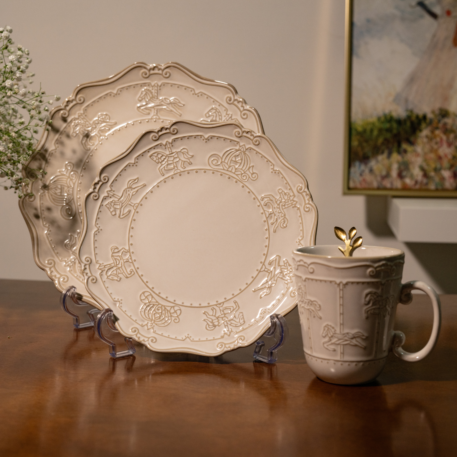 A matching bone china collection featuring a 10-inch dinner plate, a 7-inch quarter plate, a coffee mug, and a gold carved tea spoon, all with embossed carousel motifs