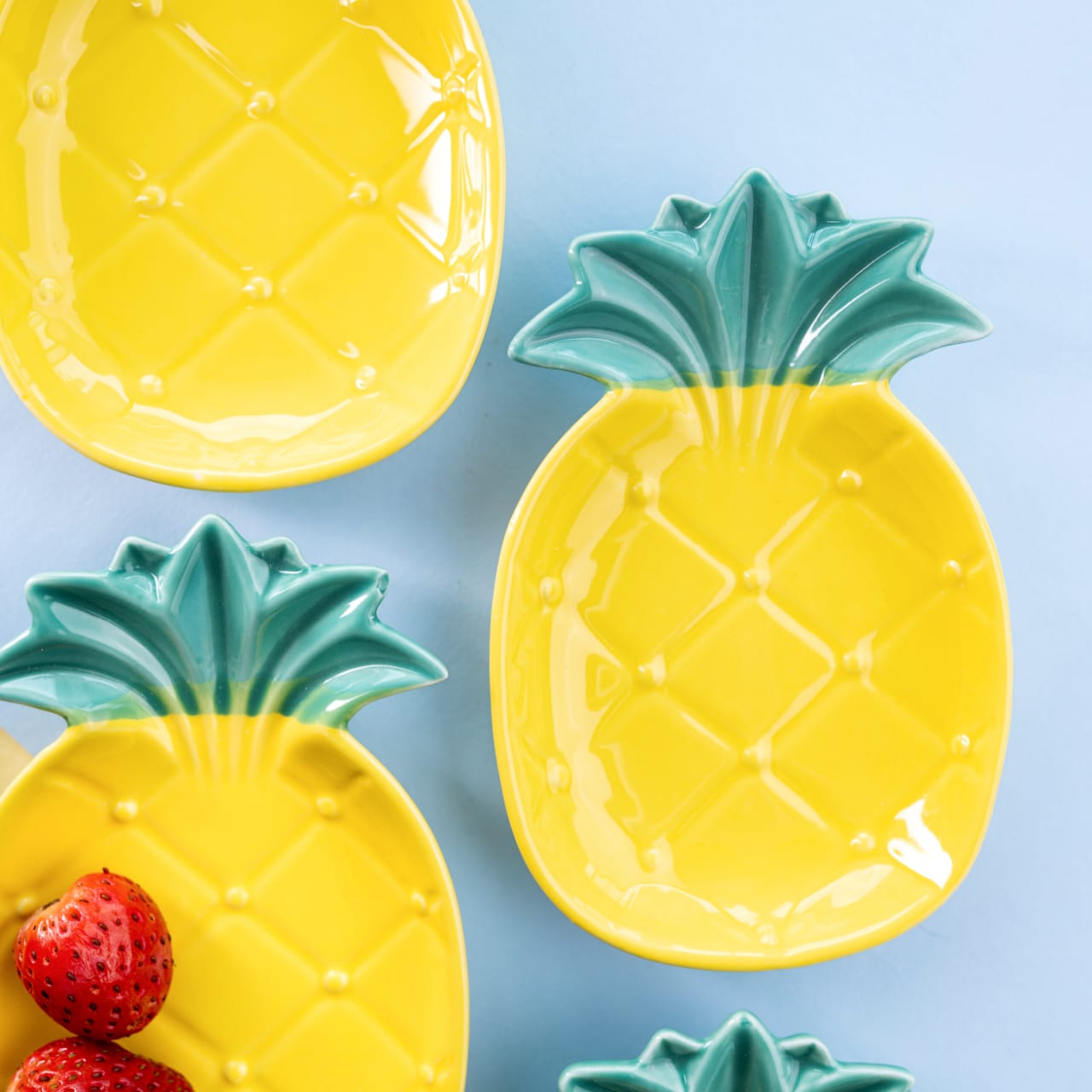 Detailed close-up view of yellow pineapple-shaped bone china snack plates with green textured crowns
