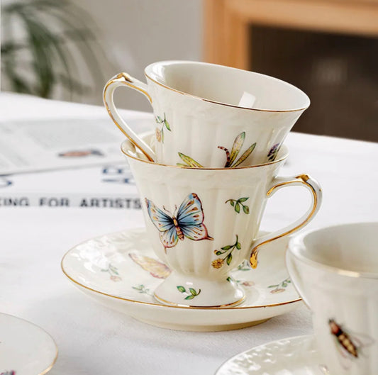 Bone china enchanted gardens tea cup and saucer with butterfly and floral motif styled on white surface - Birdy Home Design