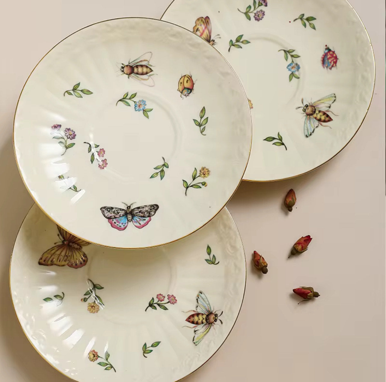 Bone china enchanted gardens three saucers each with unique butterfly and insect motif, top-down view