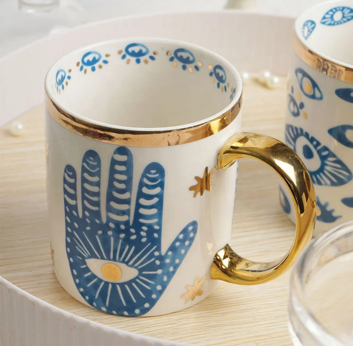 Bone china Turkish Evil Eye mug featuring the blue hand design and a gold handle