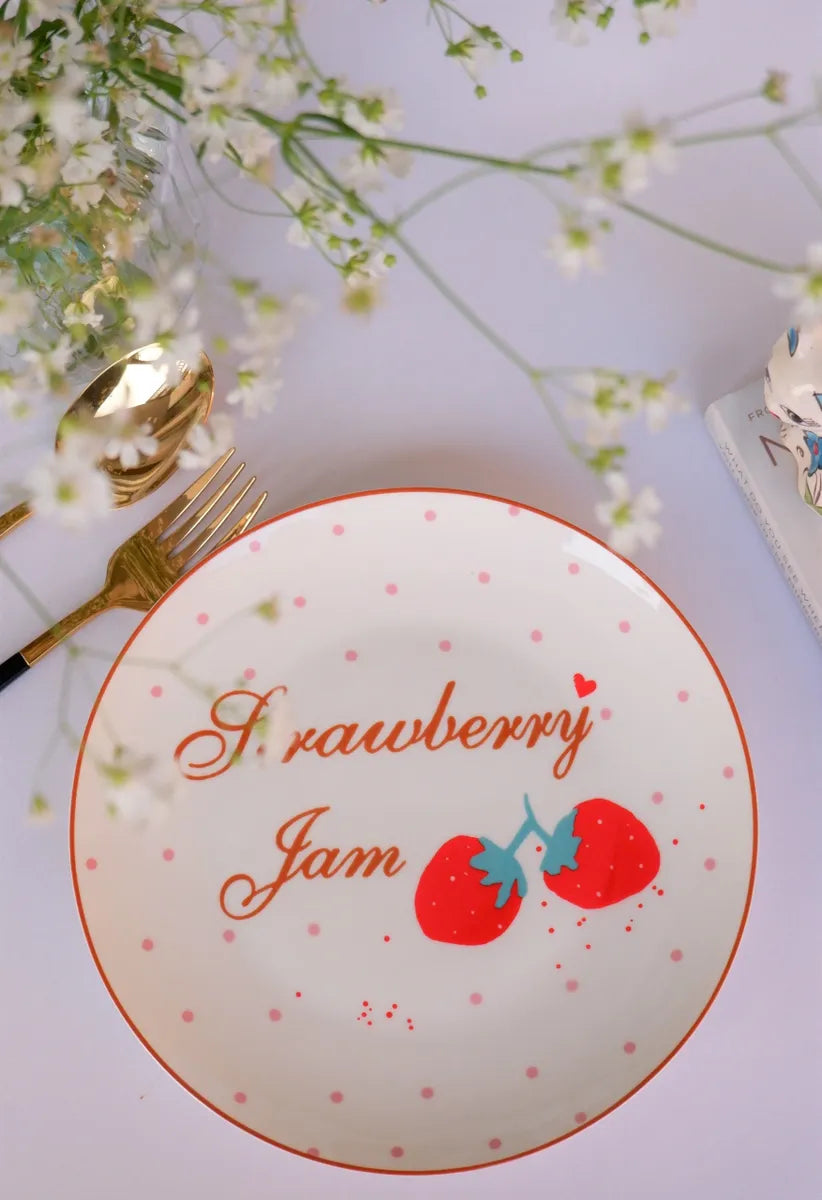 An 8-inch white bone china plate featuring red "Strawberry Jam" cursive text, red strawberry illustrations