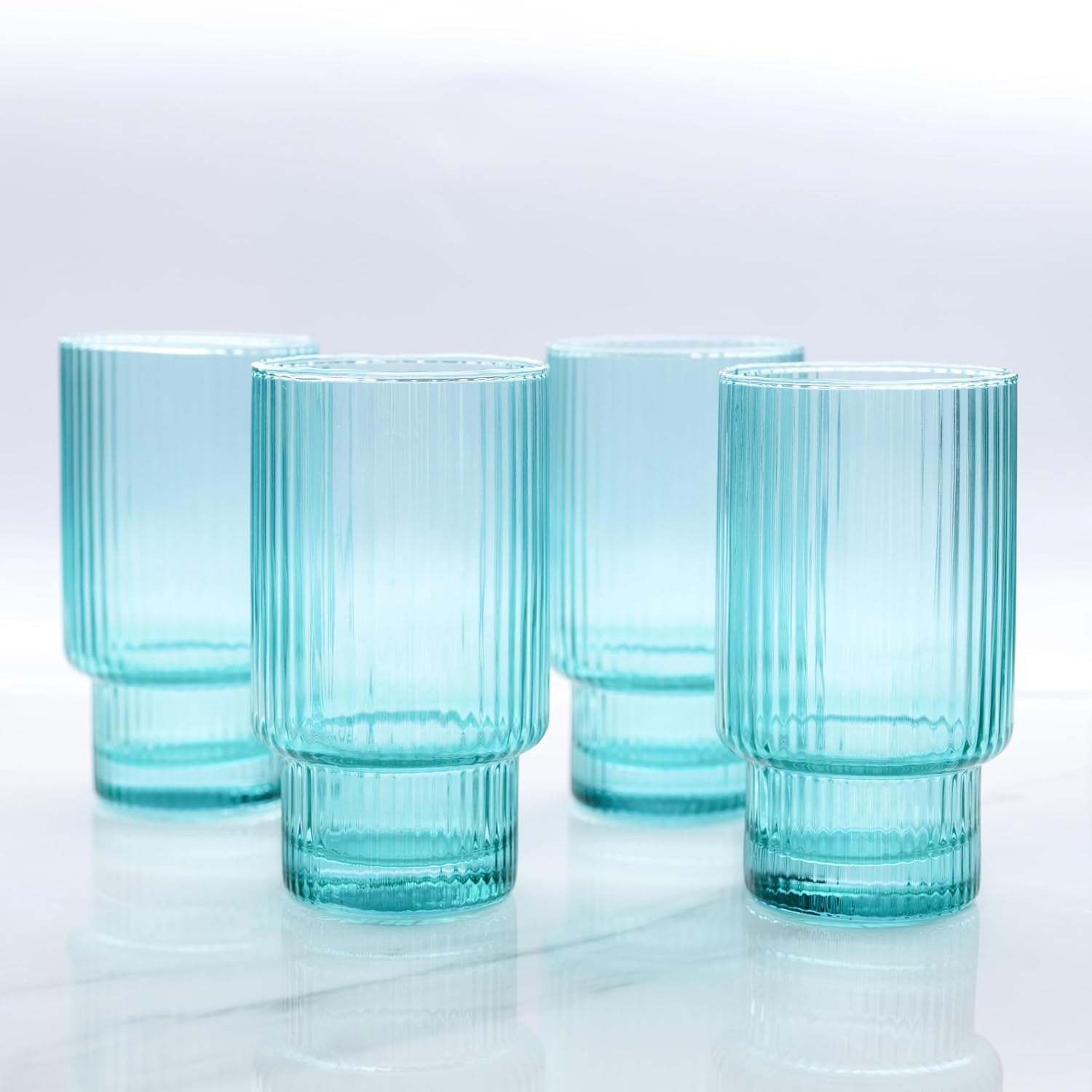 Four tall glass ribbed aqua drinking glasses