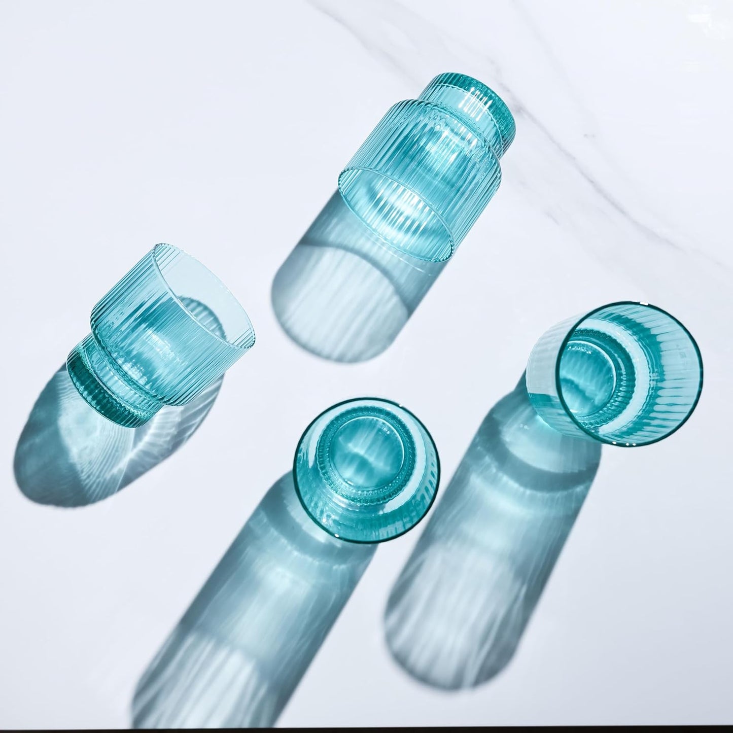 Four small glass ribbed aqua drinking glasses