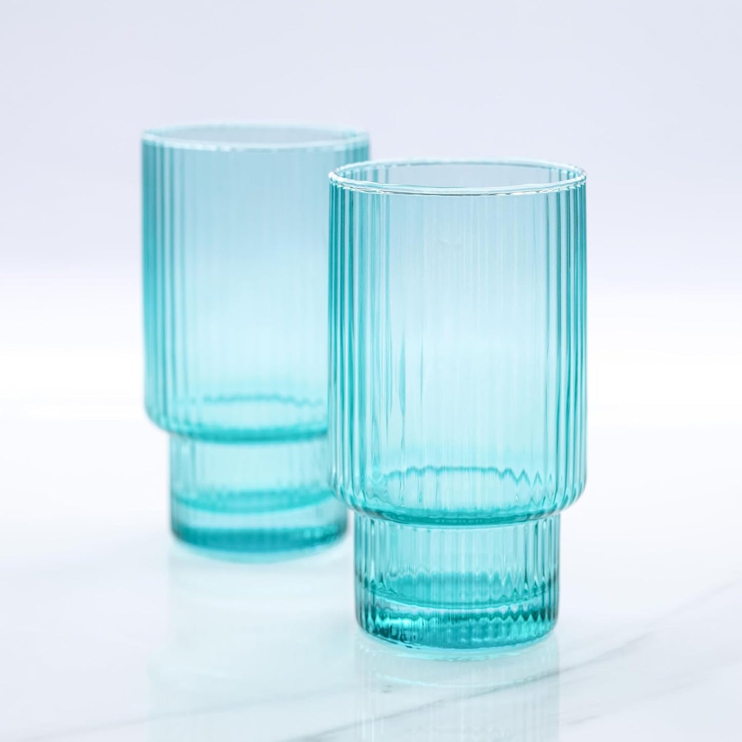 Two tall glass ribbed aqua drinking glasses