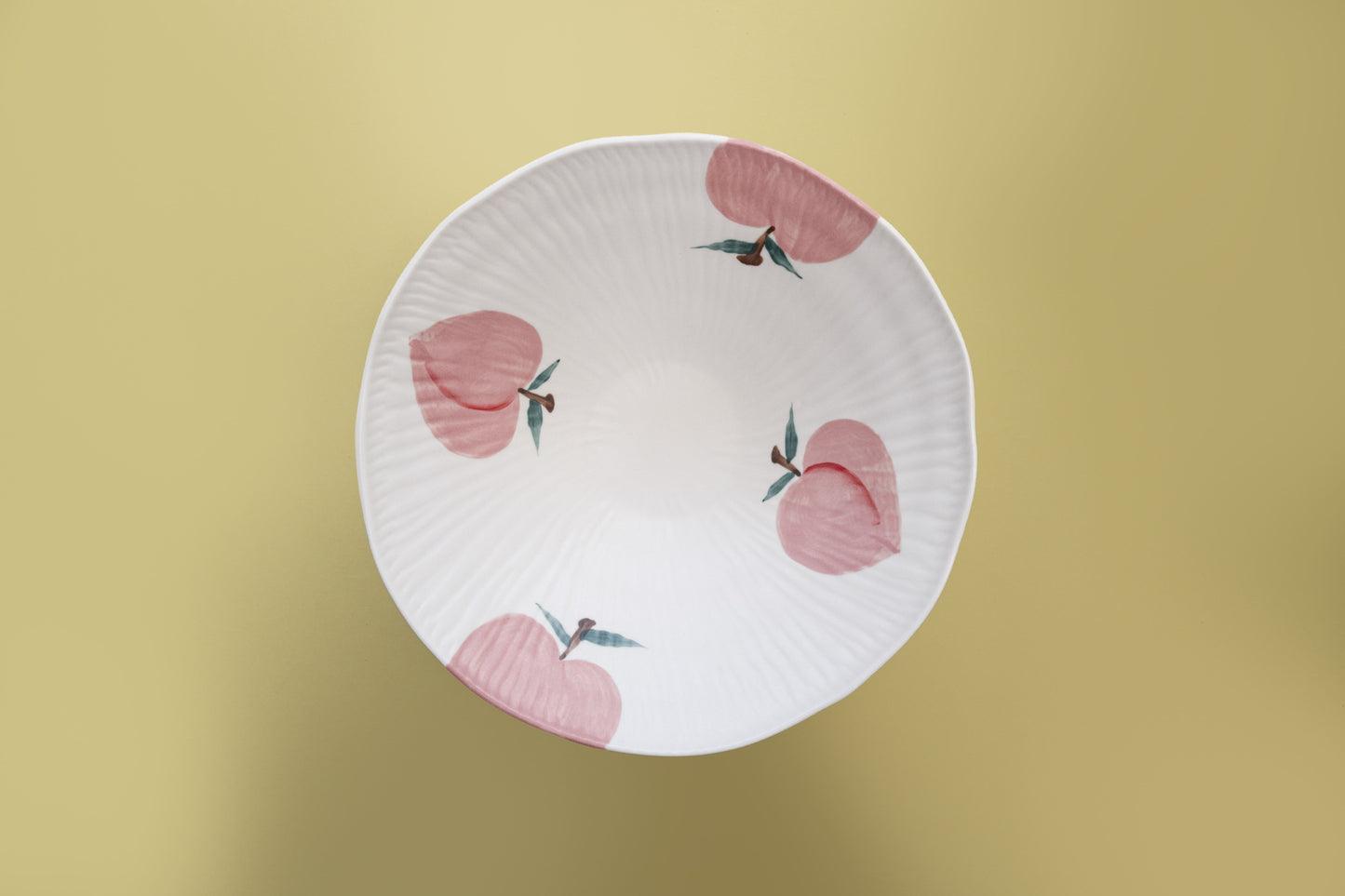 Top view of a white stoneware salad bowl featuring a pink peach pattern - Birdy Home Design