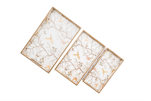 Side view of a rectangular white wooden tray with a gold border and gold chinoiserie bird and branch pattern